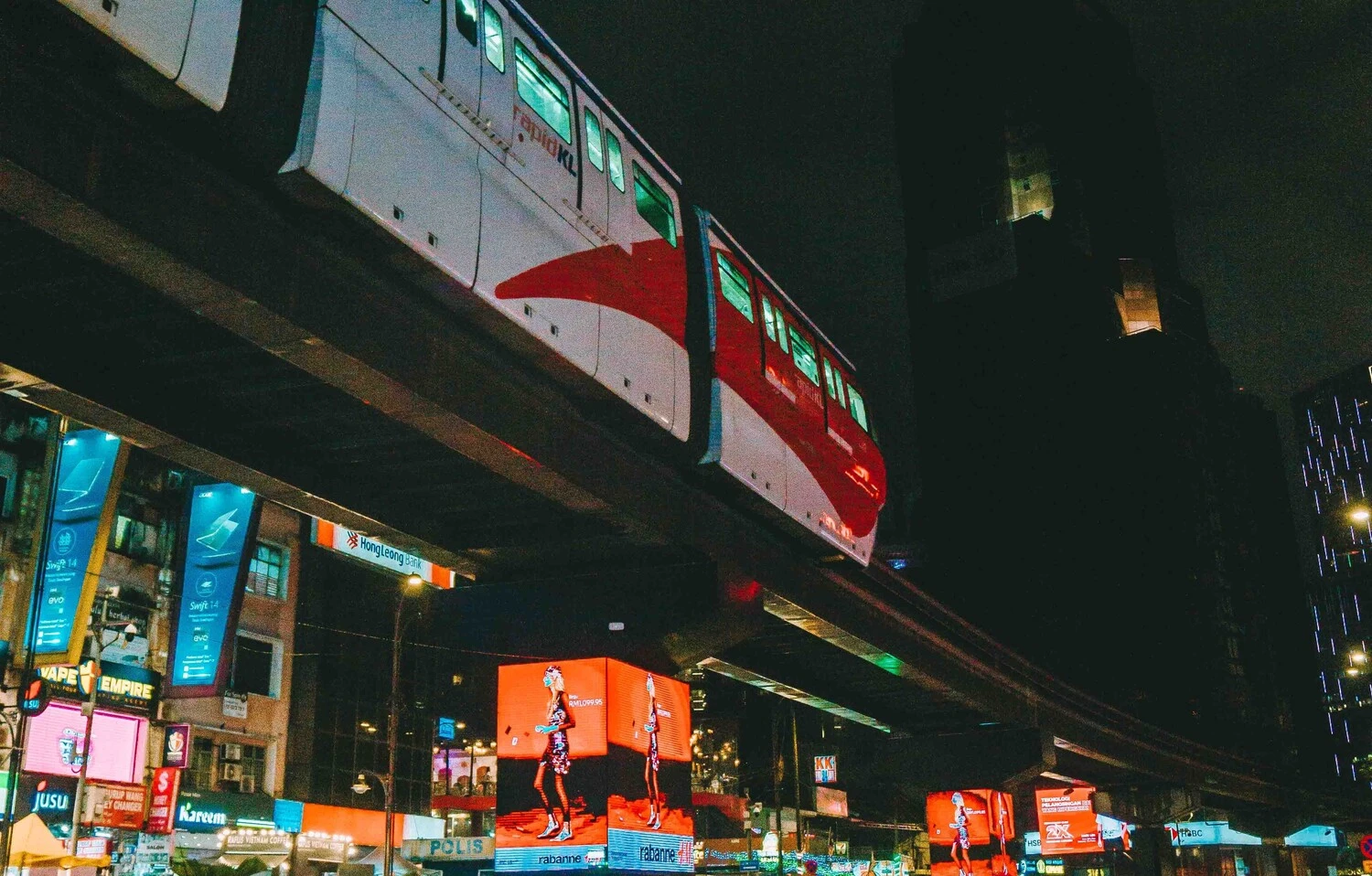 The KL Monorail passing above illuminated billboards and shopfronts in Bukit Bintang at night