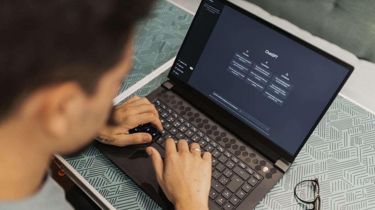 Person typing a question into ChatGPT on a laptop
